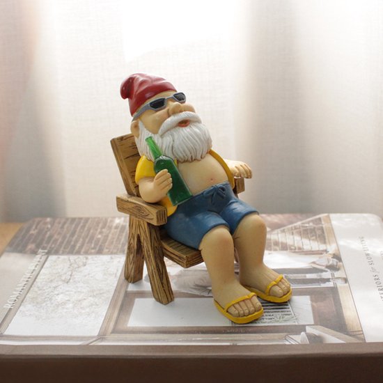 Vrolijke kabouter in ligstoel - tuindecoratie met zonnebril